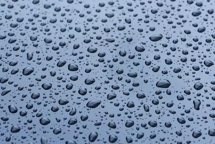 Wassertropfen auf glatter blauer Oberfl&auml;che