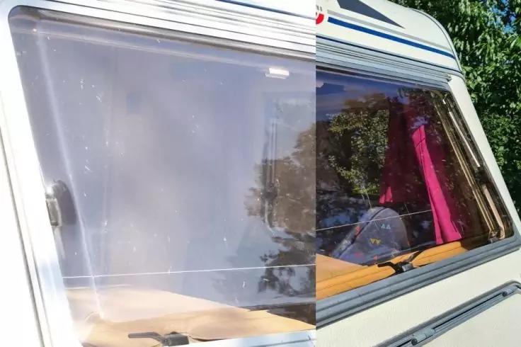 Fenster eines Fahrzeugs mit Spiegelung von B&auml;umen, pinkem Vorhang und beigen Polstern