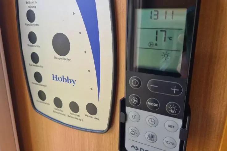 Links ein helles Panel mit der Aufschrift "Hobby" und mehreren runden Tasten; rechts ein schwarzes Ger&auml;t mit LCD-Anzeige "13:11" und "17&deg;C" sowie weiteren Tasten