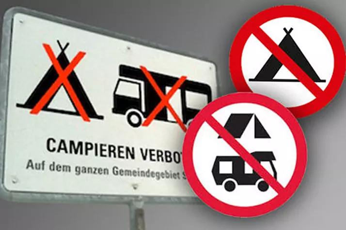Wei&szlig;es Schild mit drei durchgestrichenen Piktogrammen (Zelt, Wohnmobil, Wohnwagen) und dem Text 'CAMPEREN VERBOTEN'; daneben zwei runde rote Verbotsschilder mit durchgestrichenem Zelt und Wohnmobil