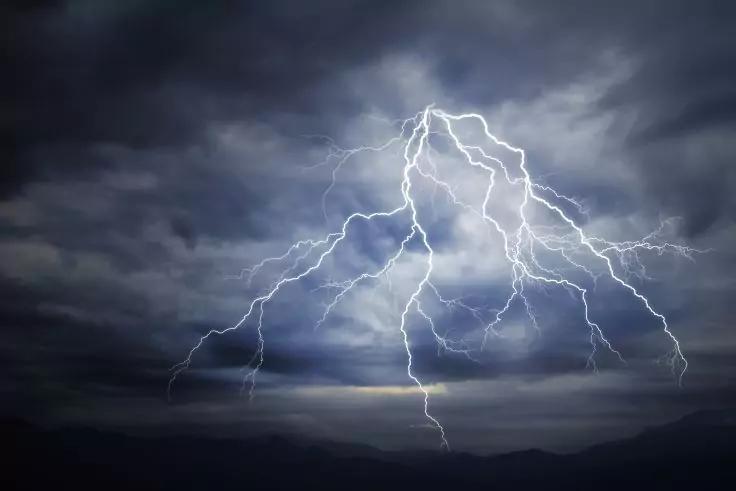 Dunkle Wolken &uuml;ber einem dunklen Horizont, mehrere sichtbare Blitze