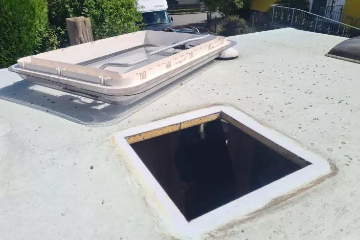 Dach eines Fahrzeugs mit zwei Dachluken, eine ge&ouml;ffnet, die andere entfernt und als quadratische &Ouml;ffnung sichtbar