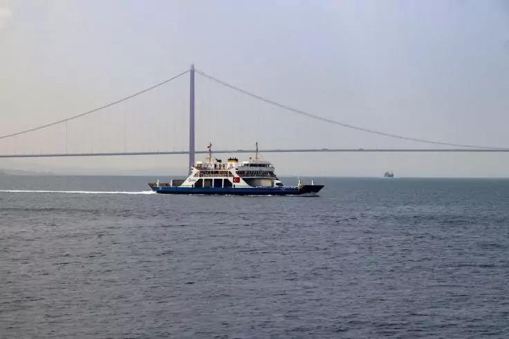 Fähre auf dem Wasser, im Hintergrund eine Hängebrücke