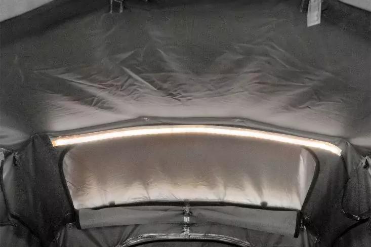 Blick auf dunkelgraue Stoffverkleidung mit silberner Innenbespannung und horizontaler LED-Leuchte, mittig sichtbare Naht und Verschluss