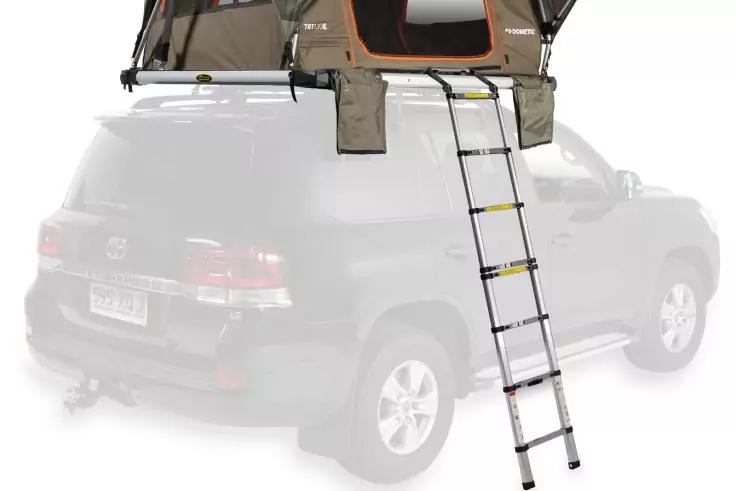 Dunkler SUV mit aufgeklapptem gr&uuml;n-beigem Dachzelt und ausziehbarer Leiter, die vom Zelt bis zum Boden reicht