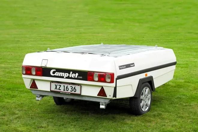 Wei&szlig;er Klappanh&auml;nger mit aufgesetztem Dach, von hinten links sichtbar, rote R&uuml;cklichter, schwarzer Seitenstreifen, Kennzeichen XZ 16 36, auf gr&uuml;nem Rasen