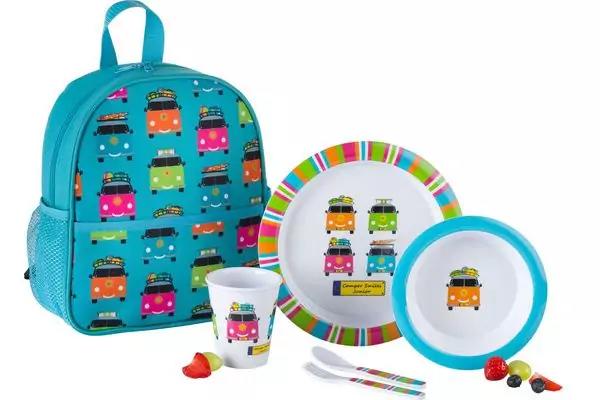 Türkisfarbener Kinderrucksack mit buntem Wohnmobilmuster; Teller mit gestreiftem Rand und Wohnmobilmotiv; Schale mit blauem Rand und Wohnmobilmotiv; Becher mit Wohnmobilmotiv; zwei Besteckteile mit bunten Griffen; drei kleine runde bunte Objekte