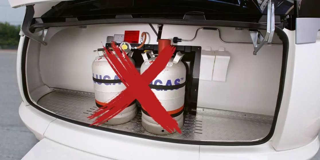 Offener Kofferraum eines wei&szlig;en Autos mit zwei Gasflaschen beschriftet 'LPG GAS' und einem gro&szlig;en roten X dar&uuml;ber
