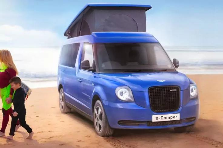 Blauer Camper mit aufgeklapptem Dach auf Sandstrand, Meer im Hintergrund, links drei Personen (eine Erwachsene, zwei Kinder)