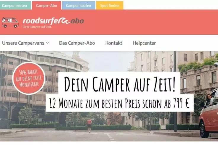 Website-Header mit korallfarbener Leiste, roadsurfer abo-Logo links, Navigationsmenü, Stadtfoto im Hintergrund, weißes Textfeld mit dem Schriftzug 'Dein Camper auf Zeit! 12 Monate zum besten Preis schon ab 799 €', roter Camper vorne rechts, rundes ro