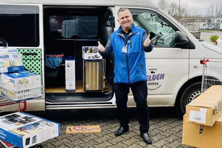 Mann steht neben offenem Lieferwagen, zeigt beide Daumen nach oben; Kartons und Haushaltsger&auml;te im Wagen und auf dem Boden