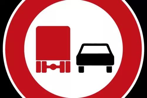 Rundes Verkehrsschild mit rotem Rand, wei&szlig;er Innenfl&auml;che und zwei Fahrzeugpiktogrammen: links rotes Lkw-Symbol, rechts schwarzes Pkw-Symbol