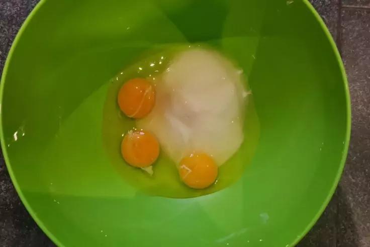 Gr&uuml;ne Sch&uuml;ssel mit drei Eigelben und einer wei&szlig;en Substanz