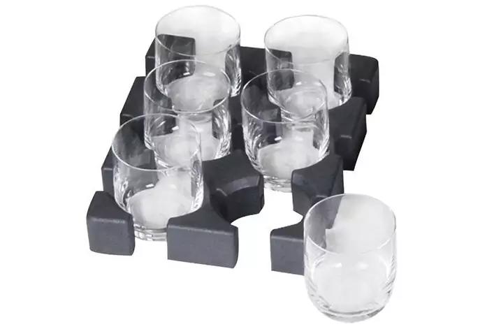 Sechs klare Gl&auml;ser in einer schwarzen Schaumstoffhalterung, ein Glas vor der Halterung