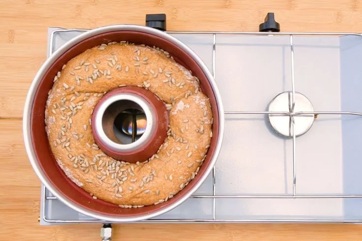 Ringf&ouml;rmiger Kuchen mit Sonnenblumenkernen in einer Rohrkuchenform auf einem Herd mit Metallrost