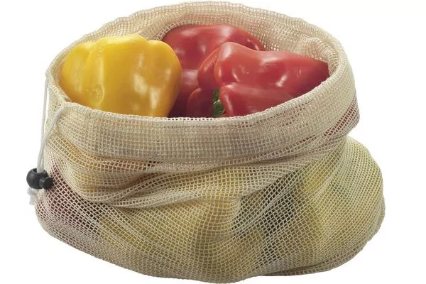 Netzbeutel mit einer gelben, mehreren roten und einer teilweise sichtbaren gr&uuml;nen Paprika auf wei&szlig;em Hintergrund