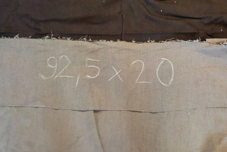 Grauer Stoff mit weißer Kreideschrift '92,5 x 20'