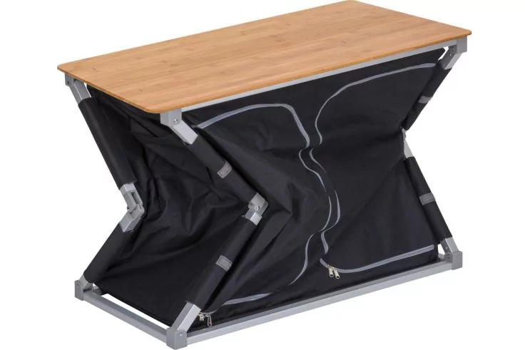 Kleiner Tisch mit hellem Holzplattenaufsatz, schwarzer, faltbarer Stoffbasis und grauem Metallgestell in Z‑Form mit sichtbarem Rei&szlig;verschluss