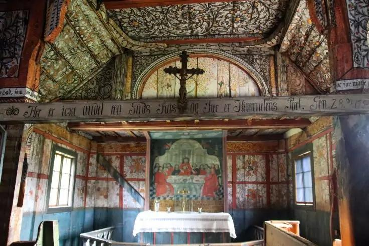 Innenraum mit Altar, Kruzifix &uuml;ber dem Altar, bemalte Holzw&auml;nde und -decke, Fenster und Sitzb&auml;nke
