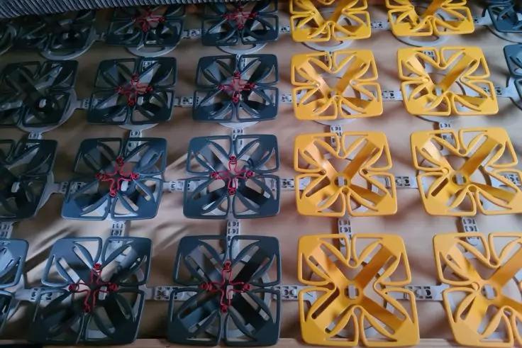 Reihen gelber und schwarzer quadratischer Teile mit sternf&ouml;rmigen Aussparungen und roten Mittelteilen auf hellem Untergrund