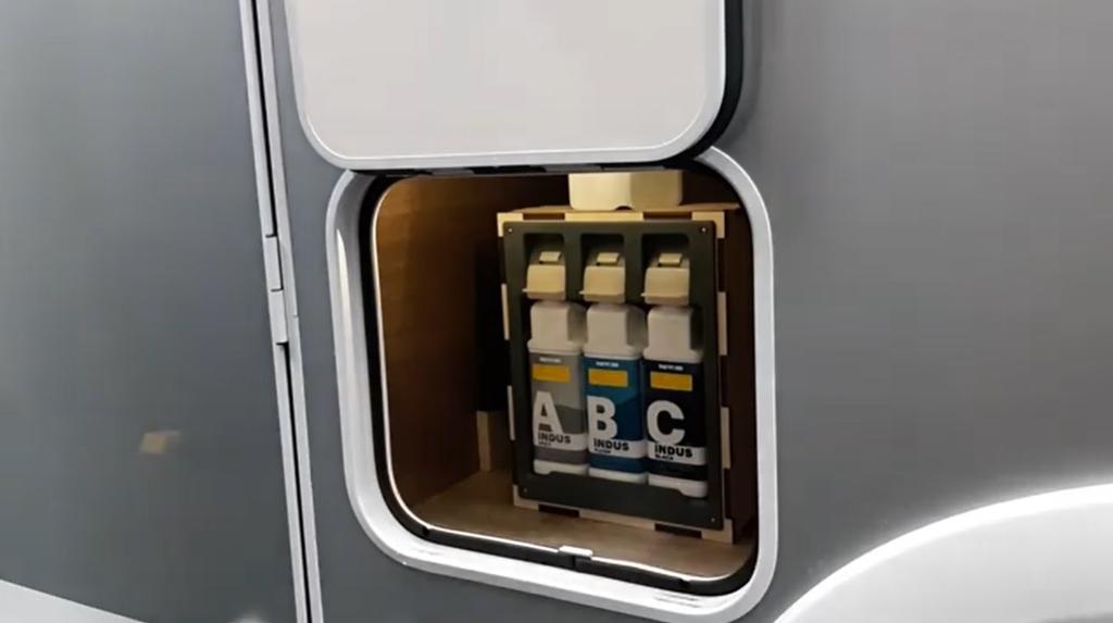 Offene Klappe in einer silbernen Au&szlig;enwand; im Innenraum drei aufrecht stehende Kartuschen in einer Halterung, jeweils mit den Buchstaben 'A', 'B', 'C'