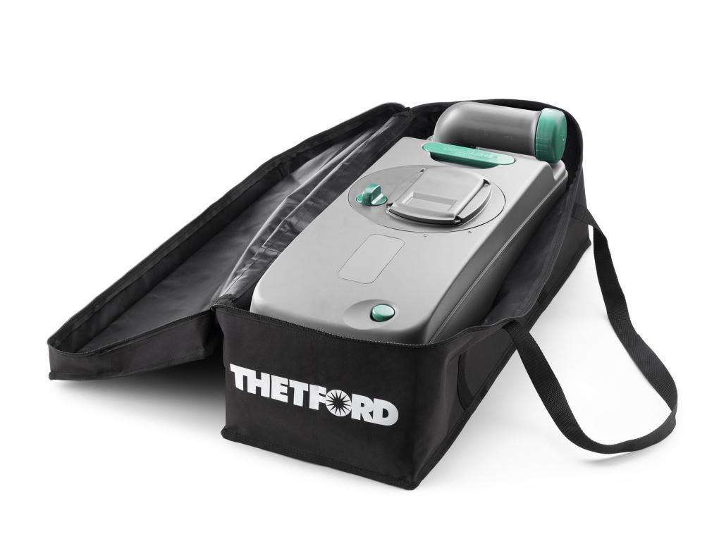 Graugr&uuml;nes Kunststoffger&auml;t mit runden Bedienelementen in einer teilweise ge&ouml;ffneten schwarzen Tragetasche mit wei&szlig;em "THETFORD"-Schriftzug und Schulterriemen