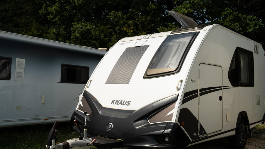 Zwei nebeneinander stehende Wohnwagen, vorn ein weißer Wohnwagen mit Aufschrift KNAUS