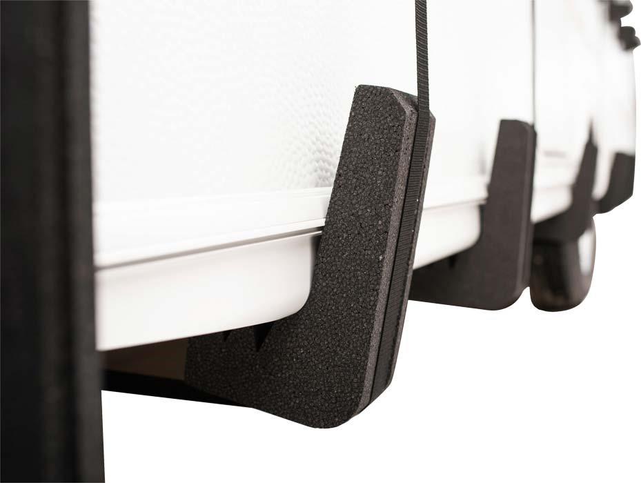 Drei wei&szlig;e Sitzr&uuml;cken in einer Reihe, an den unteren Kanten befestigte schwarze Schaumstoff-Puffer und ein vertikales schwarzes Kabel