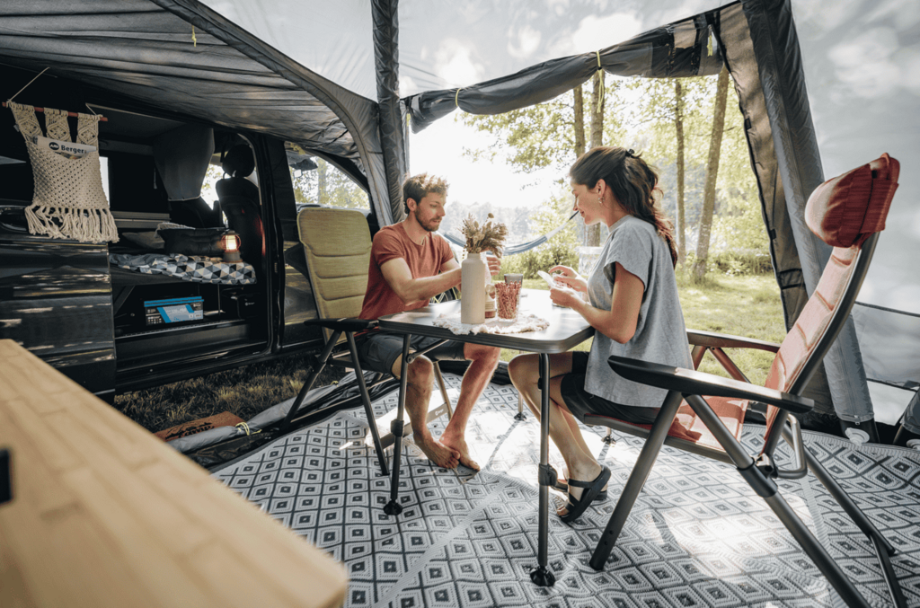 Paar im Vorzelt auf Campingstühlen 