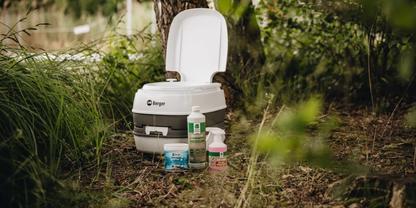 Eine Campingtoilette im Wald umgeben von Sanit&auml;rzus&auml;tzen