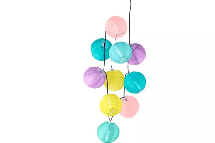 Lampions en papier de couleurs pastel suspendus à un cordon noir sur fond blanc