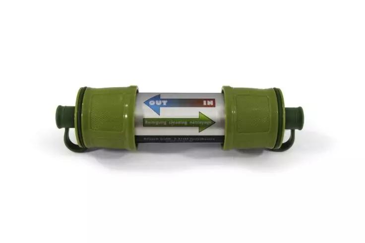 Objet cylindrique vert avec embouts verts, étiquette argentée centrale montrant une flèche verte vers la droite et des marques bleues et rouges, sur fond blanc