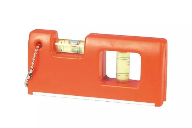 Piccolo blocco di plastica arancione con due fialette di vetro con bolle (una orizzontale, una verticale), piccola catena metallica a sinistra, sottile striscia metallica alla base, sfondo bianco