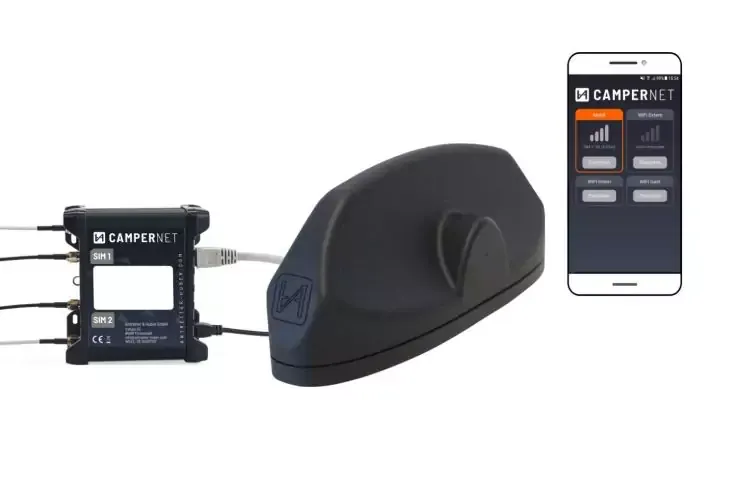 Dispositivo nero allungato e arrotondato su sfondo bianco, a sinistra un piccolo box rettangolare nero con cavi, a destra uno smartphone che mostra uno schermo di app con la scritta 'CAMPERNET', barre del segnale e pulsanti visibili