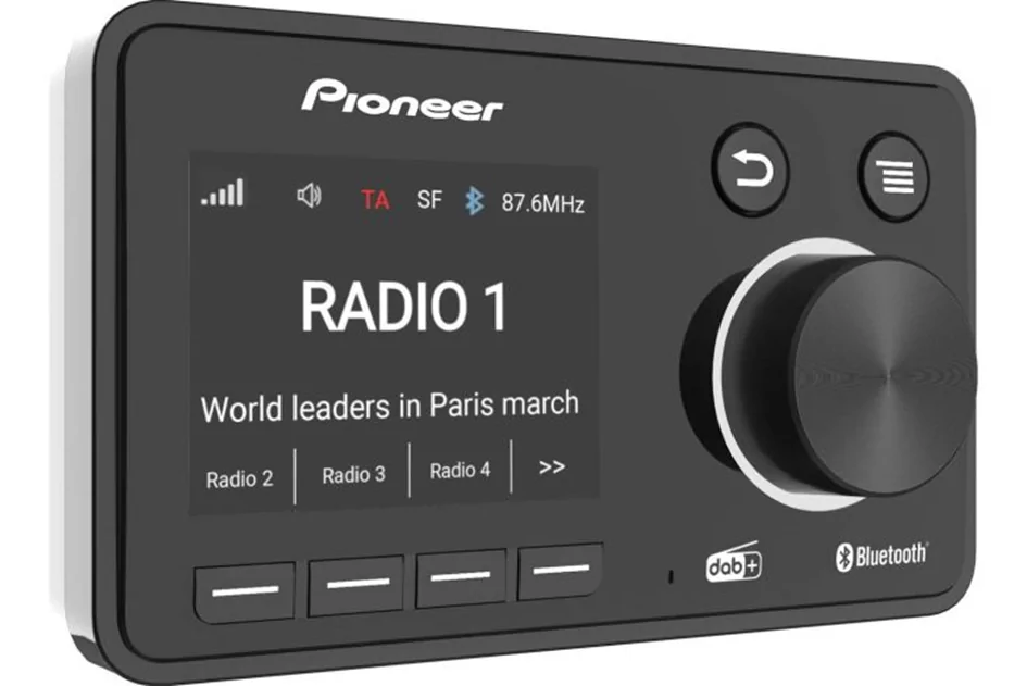 Radio Pioneer rettangolare nera; display mostra RADIO 1 e la riga World leaders in Paris march, 87,6 MHz, grande manopola a destra, quattro tasti, loghi DAB+ e Bluetooth