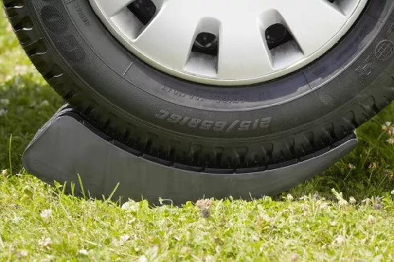 Autoband op een zwart wielblok op gras