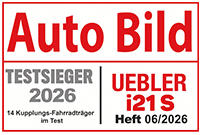 Magazintitel 'Auto Bild' in roter Schrift oben; darunter links graues Feld mit 'TESTSIEGER 2026' und kleiner Schrift '14 Kupplungs-Fahrradtr&auml;ger im Test'; rechts rotes Feld mit 'UEBLER i21S Heft 06/2026'