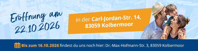 Banner tegen een blauwe lucht met wolken. Links grote tekst 'Er&ouml;ffnung am 22.10.2026'. Rechts oranje vak met 'in der Carl-Jordan-Str. 14, 83059 Kolbermoor'. Onderaan links smalle blauwe strook met 'Bis zum 16.10.2026 findest du uns noch hier: Dr.-Max-Hofmann-Str. 3, 83059 Kolbermoor'. Rechts foto van twee personen, een man met hoed en een vrouw met zonnebril, gezichten dicht bij elkaar, arm om schouder