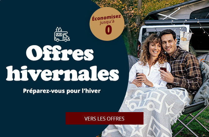 Deux personnes sont assises dans le coffre ouvert d’une voiture, toutes deux couvertes d’une couverture claire à motif d’étoiles et tiennent des tasses ; à gauche un grand espace bleu foncé avec le texte "Winter Deals", pastille ronde "bis zu -52% sparen" et bouton rouge "ZU DEN ANGEBOTEN"