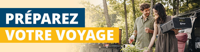 Deux personnes &agrave; c&ocirc;t&eacute; d'une voiture au coffre ouvert; &agrave; gauche une banni&egrave;re indiquant &laquo;REISE-VORBEREITUNG&raquo;; arbres en arri&egrave;re-plan