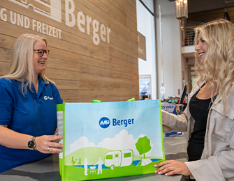 Zwei Frauen im Lager besprechen einen weißen Kanister