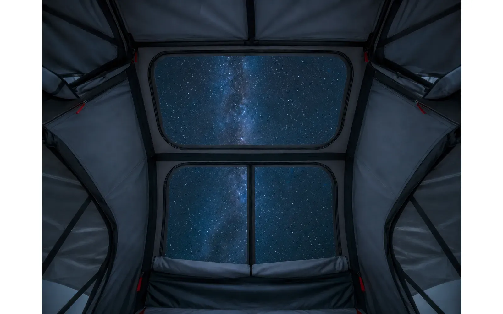 Ein leuchtender Sternenhimmel außerhalb eines Dachzelts