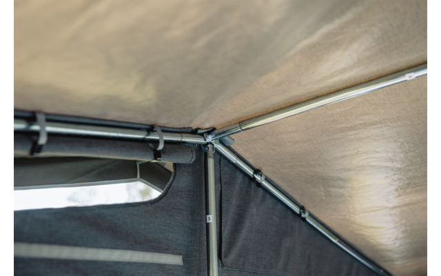 Innenseite eines Zeltdachs aus Stoff mit Metallstangen, Eckverbindung und einer kleinen rechteckigen Öffnung mit Himmelsblick