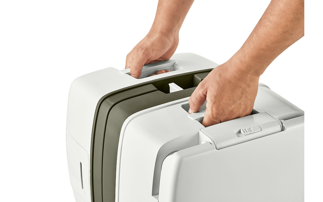 Due valigie rigide bianche affiancate, ciascuna tenuta da mani per la maniglia superiore