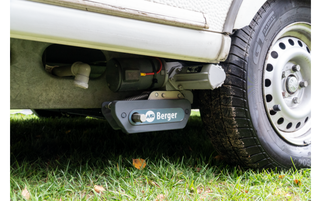 Unterseite eines Fahrzeugs mit montiertem Gerät mit Aufschrift „Berger“ neben einem Rad, Gras darunter