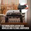 Gas grill with closed lid and thermometer on a wooden surface, two control knobs at front; inset circle shows hands holding a black side panel; wooden slatted fence in background; white bottom text: 'SEITANABLAGEN LASSEN SICH MUHELOS UND FLEXIBEL MONTIEREN'