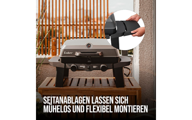 Gas grill with closed lid and thermometer on a wooden surface, two control knobs at front; inset circle shows hands holding a black side panel; wooden slatted fence in background; white bottom text: 'SEITANABLAGEN LASSEN SICH MUHELOS UND FLEXIBEL MONTIEREN'