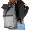 Person von hinten mit schwarzem Rucksack aus Stoff und Netzmaterial, trägt schwarze Kleidung und blaue Jeans