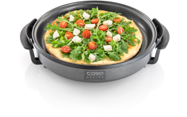 Pizza in einer grauen elektrischen Pfanne mit Rucola, halbierten Kirschtomaten und Mozzarellawürfeln