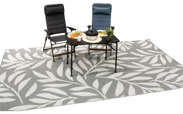 Zwei gepolsterte Stühle (dunkelgrau und blau), ein schwarzer Beistelltisch mit Kanne, Tassen, Tellern und kleinen Pflanzen, alles auf einem großen grauen Teppich mit weißem Blattmuster